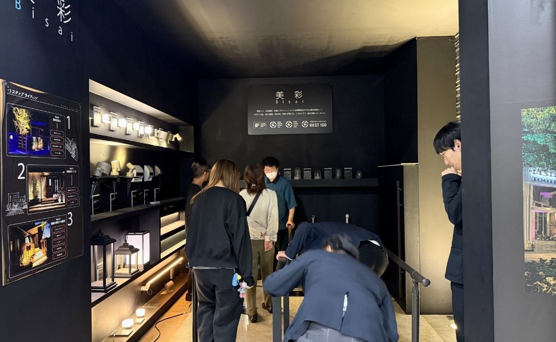 LIXILエクステリア照明『12V美彩』の展示品を見ているスタッフ