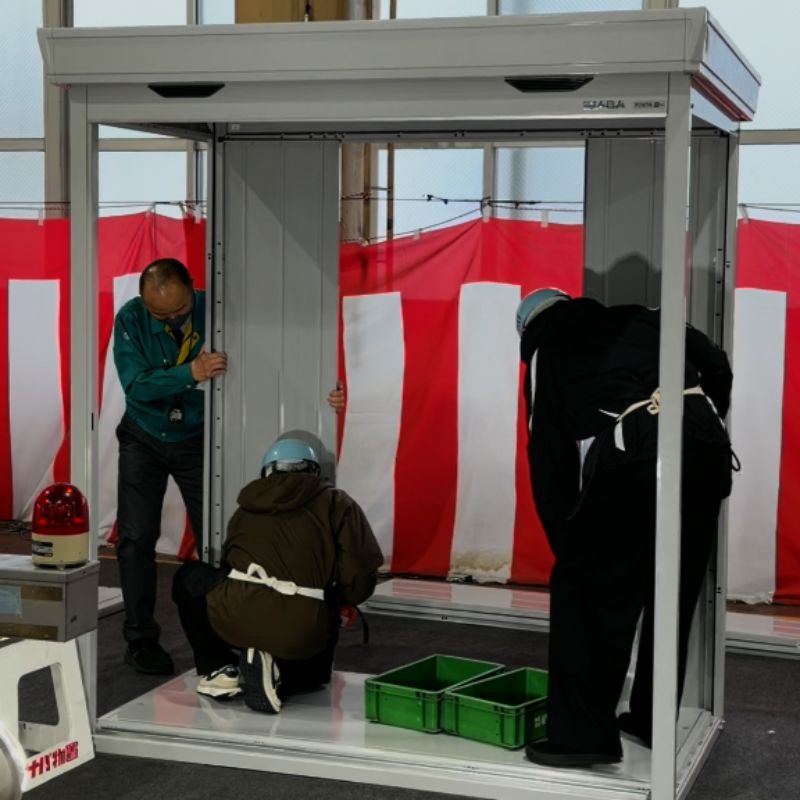 イナバ物置フォルタの壁パネルをはめ込む組み立て作業の様子