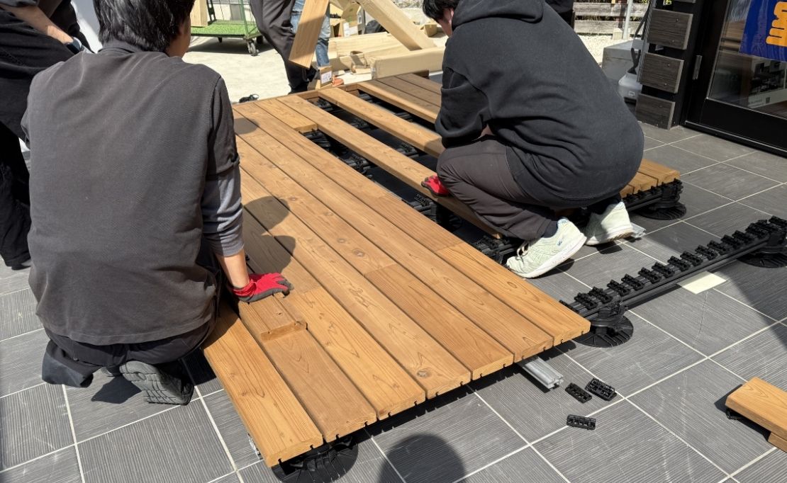 エステックウッドの天然木デッキ材を上から踏み込んで固定する様子